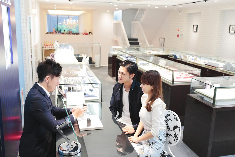 スタッフが丁寧に結婚指輪選びを案内している様子